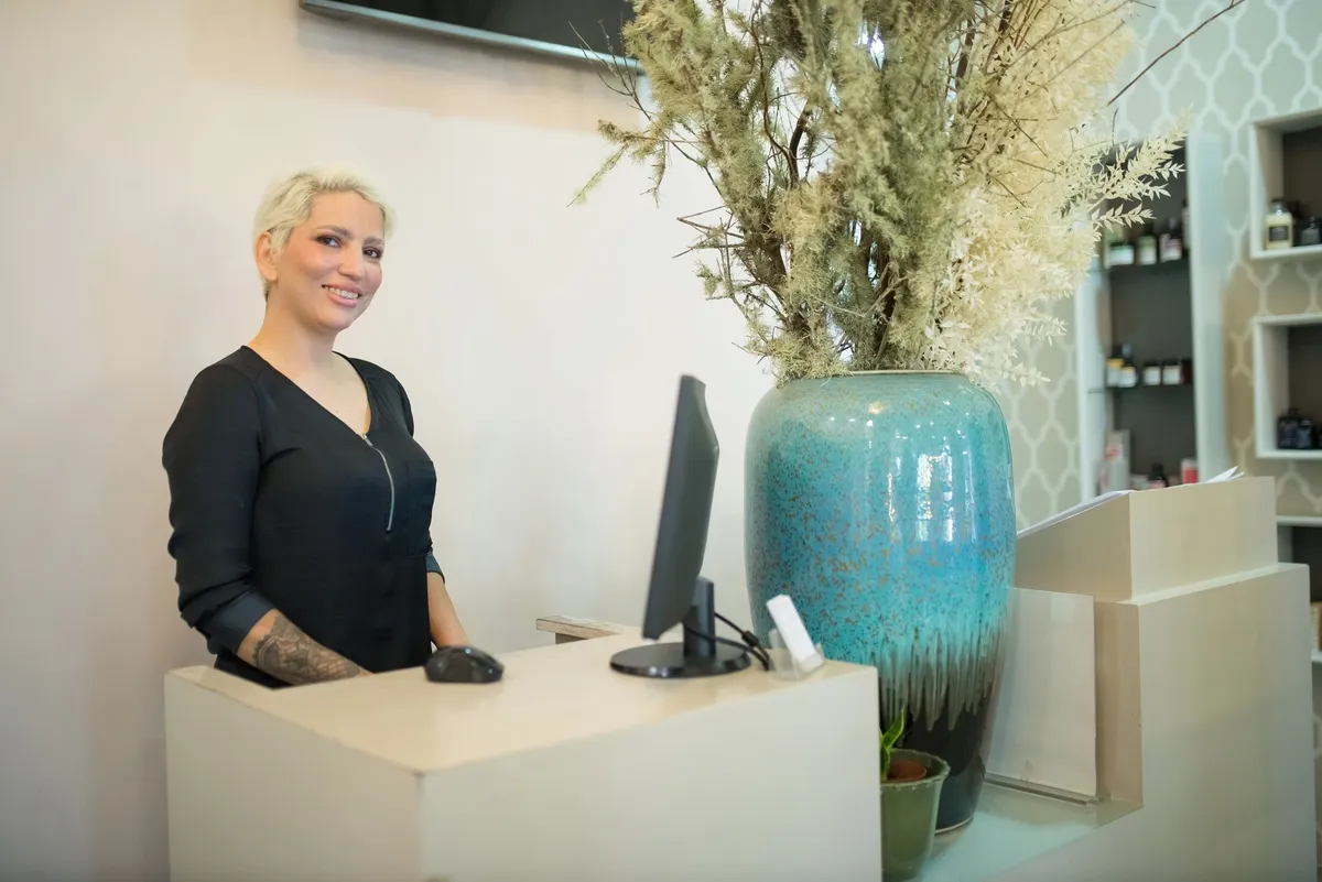 Smiling receptionist at a salon front desk