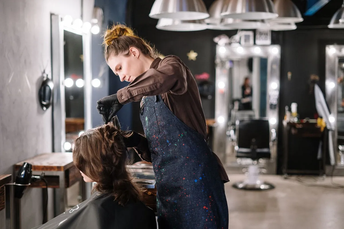 Stylist applying hair color to a client in a modern salon