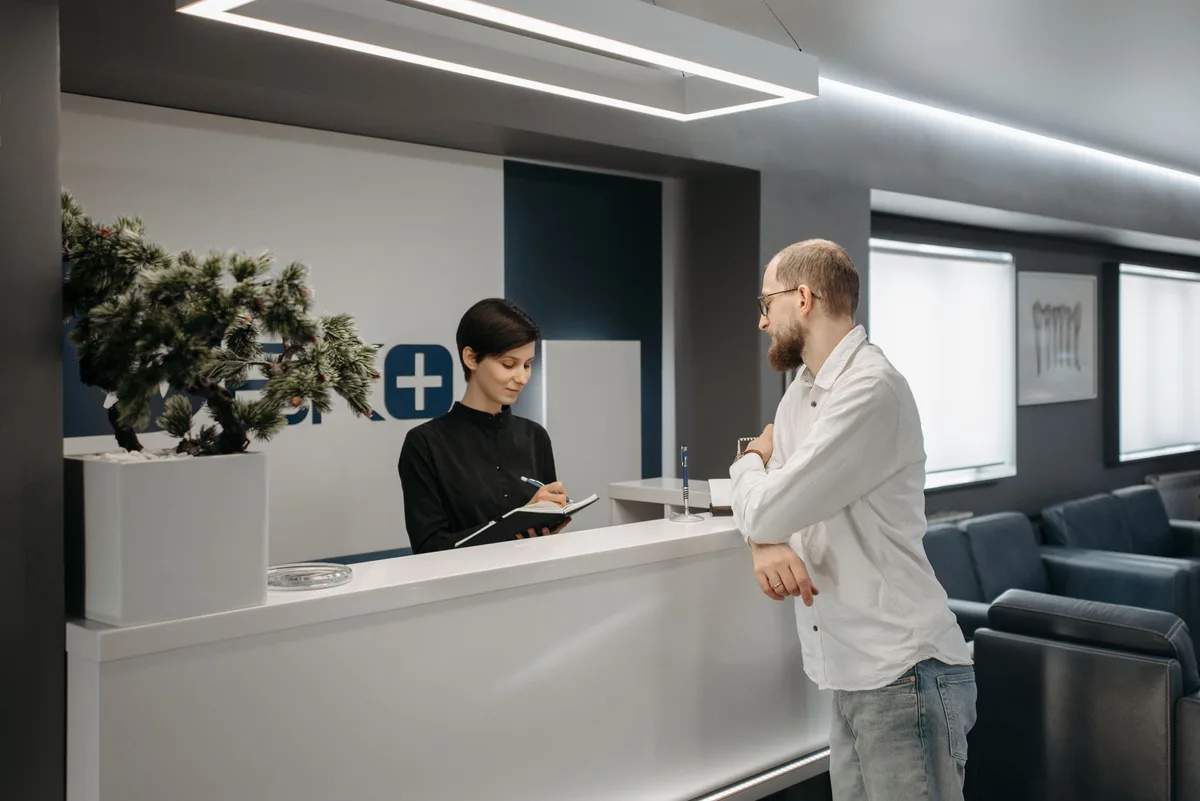 Client standing at a modern reception counter at check-in
