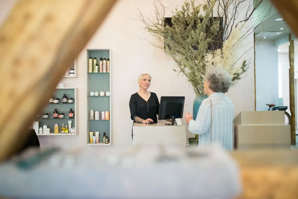 Hairdresser talking with her client at the salon counter