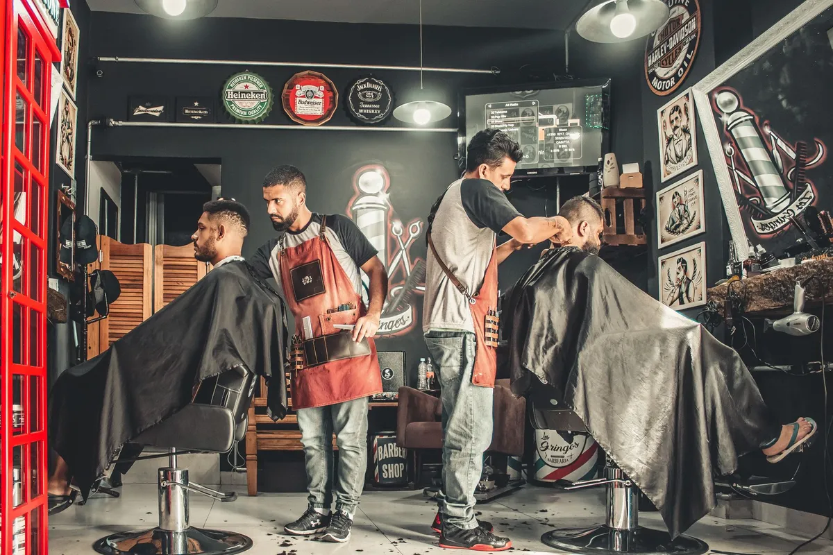 Busy barbershop with two haircuts underway